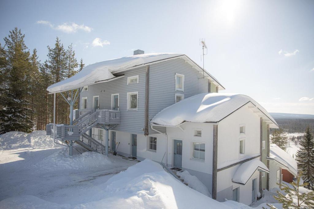 una casa está cubierta de nieve con nieve en Näköalahuoneisto AARNI & NAAVA, en Ukkohalla