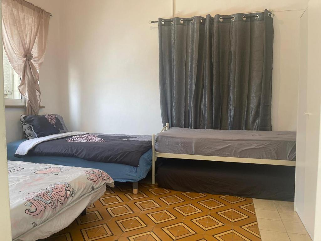 a room with two beds and a curtain at jerusalem city couple,group and family friendly hostel in Jerusalem