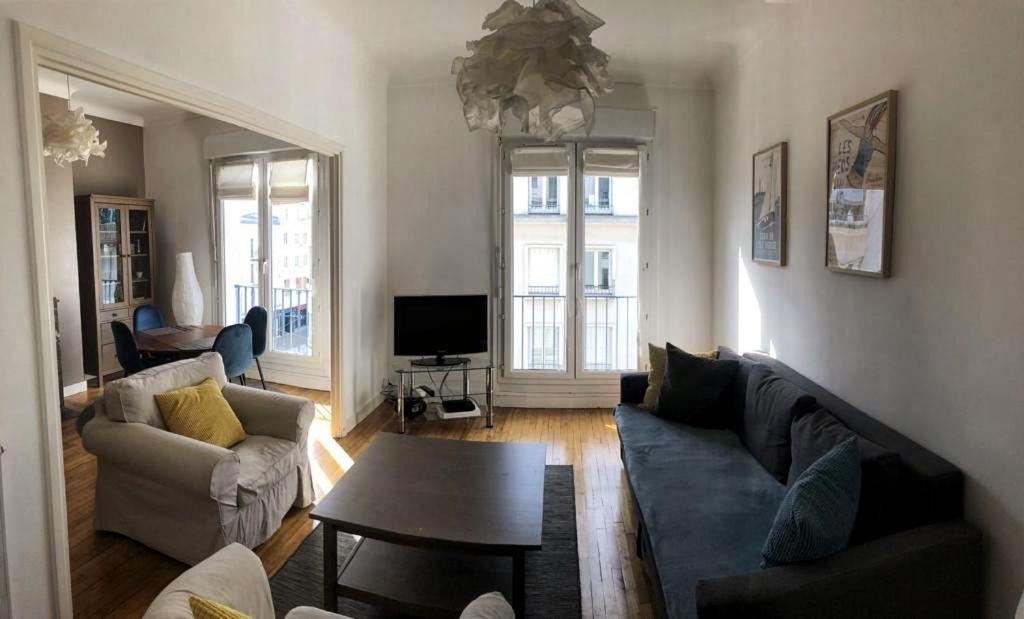 uma sala de estar com um sofá e uma mesa em L'Aiguillon, bel appartement hyper-centre em Brest