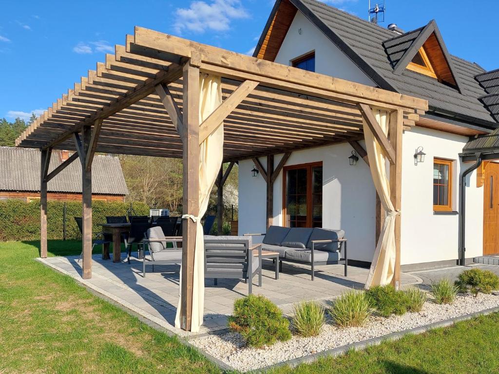 a wooden pergola on a patio of a house at Domek nad Marychą - Zelwa in Zelwa