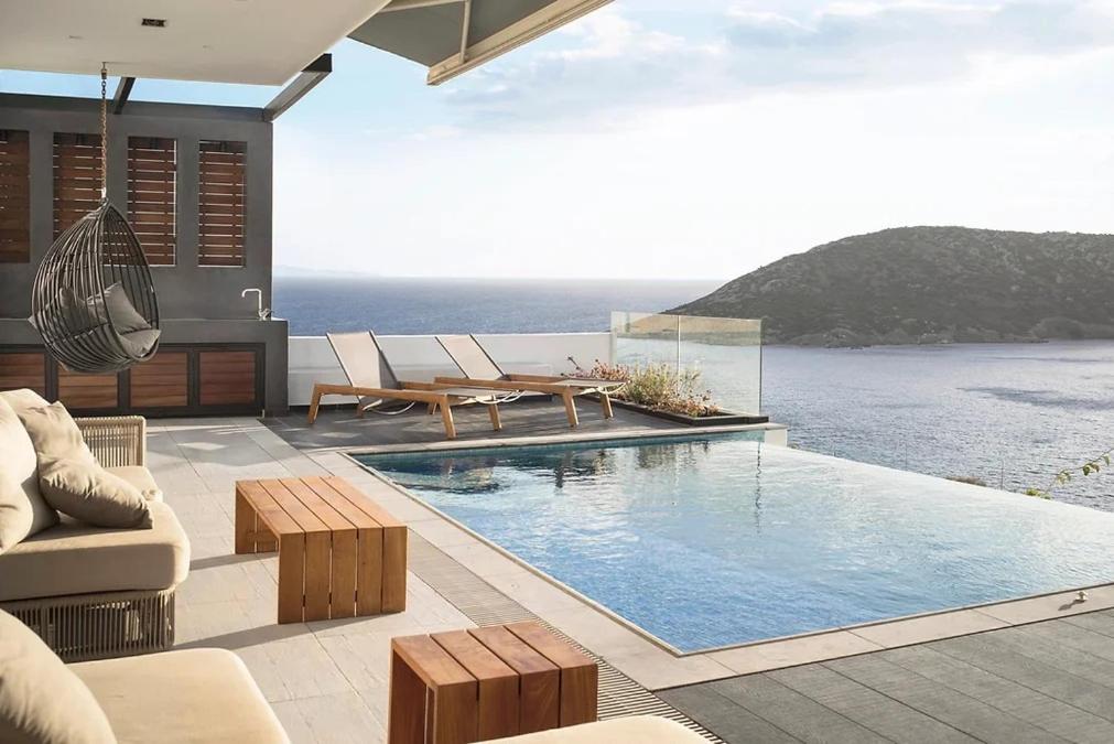 a house with a swimming pool with a view of the ocean at Athens riviera beach villa in Anavissos