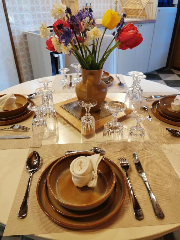 a table with plates and utensils and flowers on it at Le gîte du Brouage in Chauny
