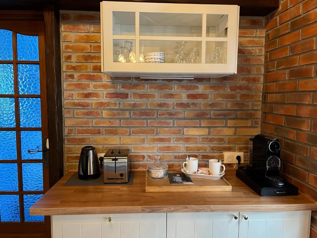 a kitchen with a counter with a brick wall at Le gîte du Brouage in Chauny