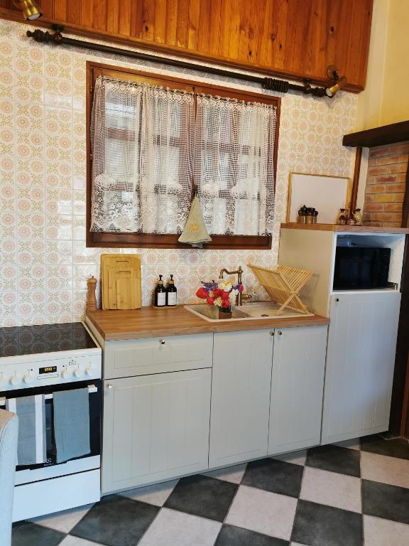 a kitchen with white cabinets and a counter top at Le gîte du Brouage in Chauny