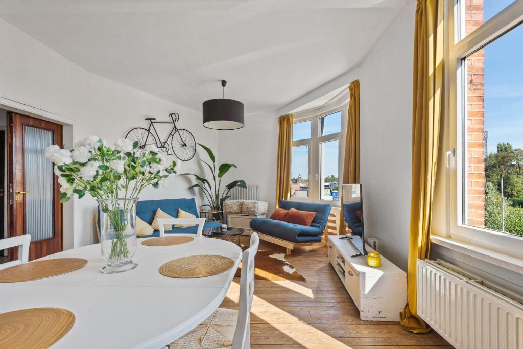 a living room with a white table and chairs at Cozy Antwerp - Sunny Zurenborg in Antwerp