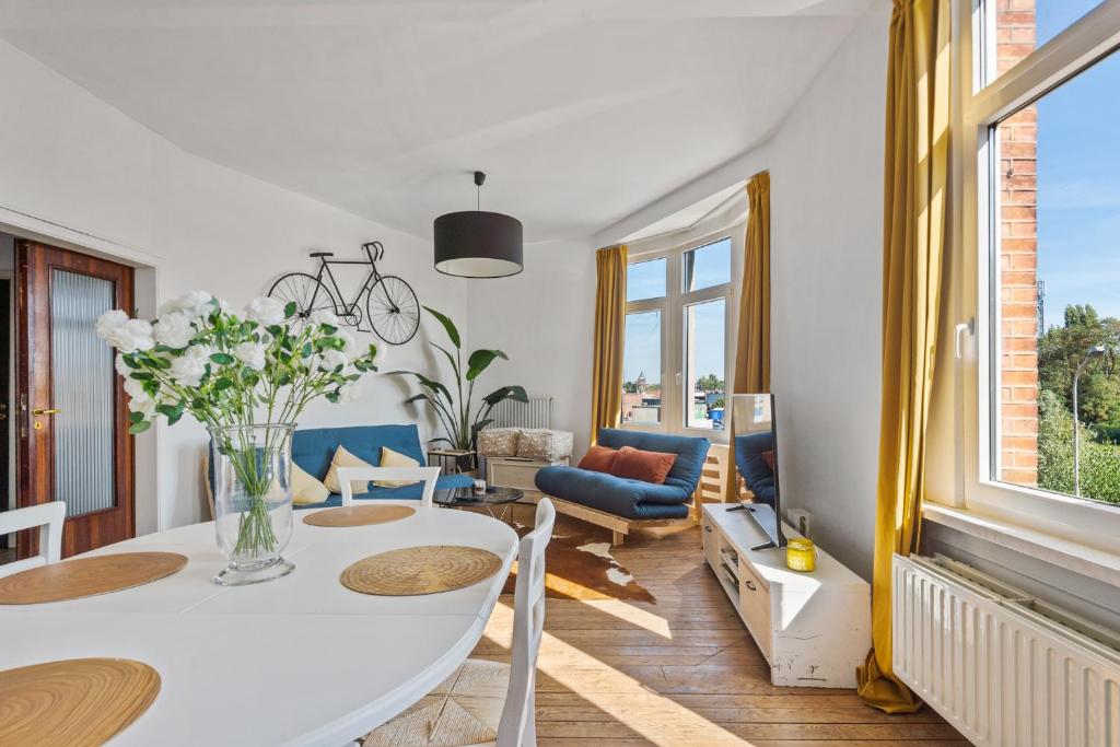 a living room with a white table and chairs at Cozy Antwerp - Sunny Zurenborg in Antwerp