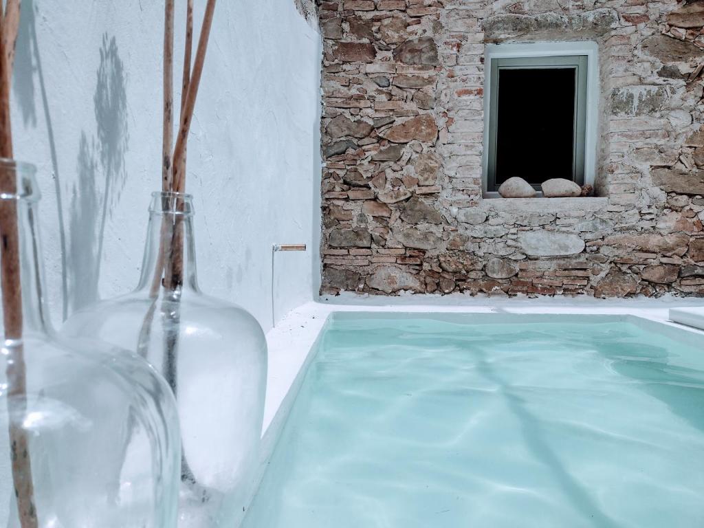 un jarrón de cristal sentado en una mesa de cristal con una ventana en CAN TANDO Restored catalan old barn to enjoy peaceful rural simplicity, en Sant Jordi Desvalls