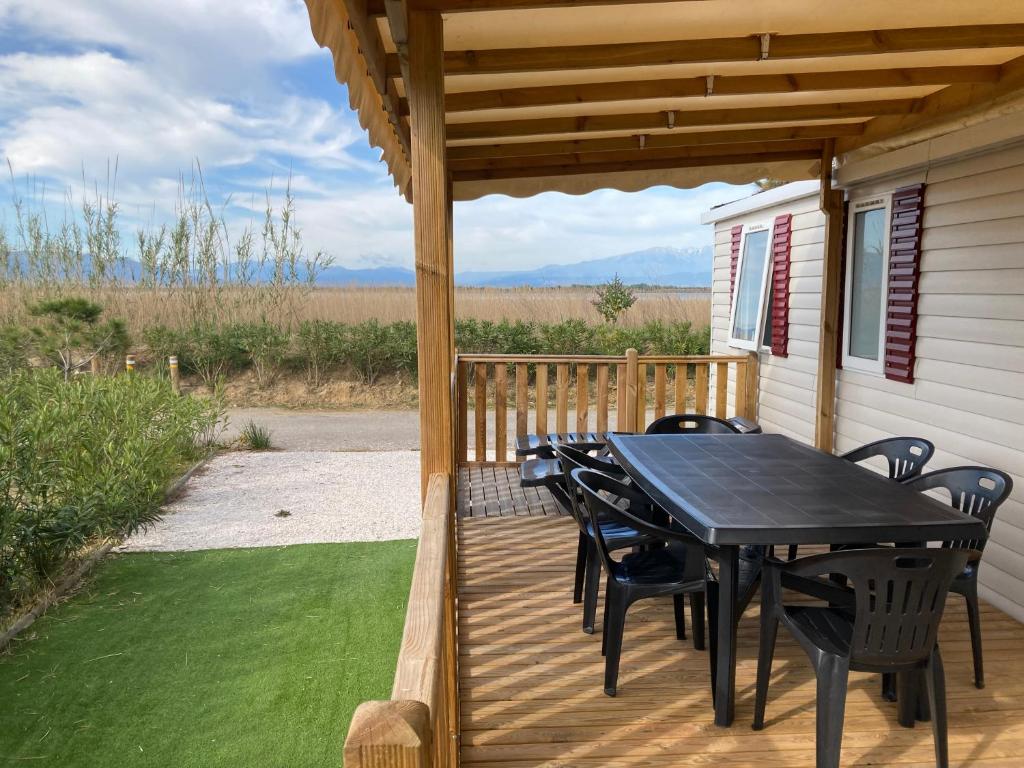 un patio con mesa y sillas en una terraza en Mobil home 3 chambres mar estang 4 étoiles !, en Canet-en-Roussillon