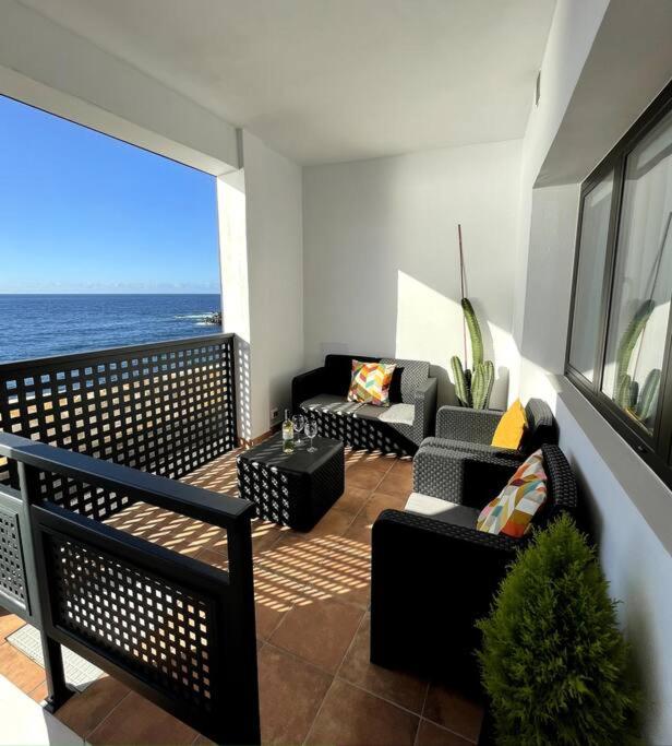 balkon z kanapami i widokiem na ocean w obiekcie Moderno apartamento frente al mar w Puerto de la Cruz