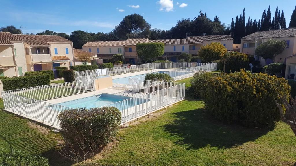 une clôture autour d'une piscine dans une cour dans l'établissement VILLAGE DE LA MER, à La Londe-les-Maures