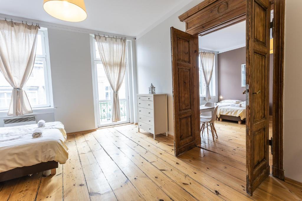 a bedroom with two beds and a large window at Apartamenty Kopernika in Toruń
