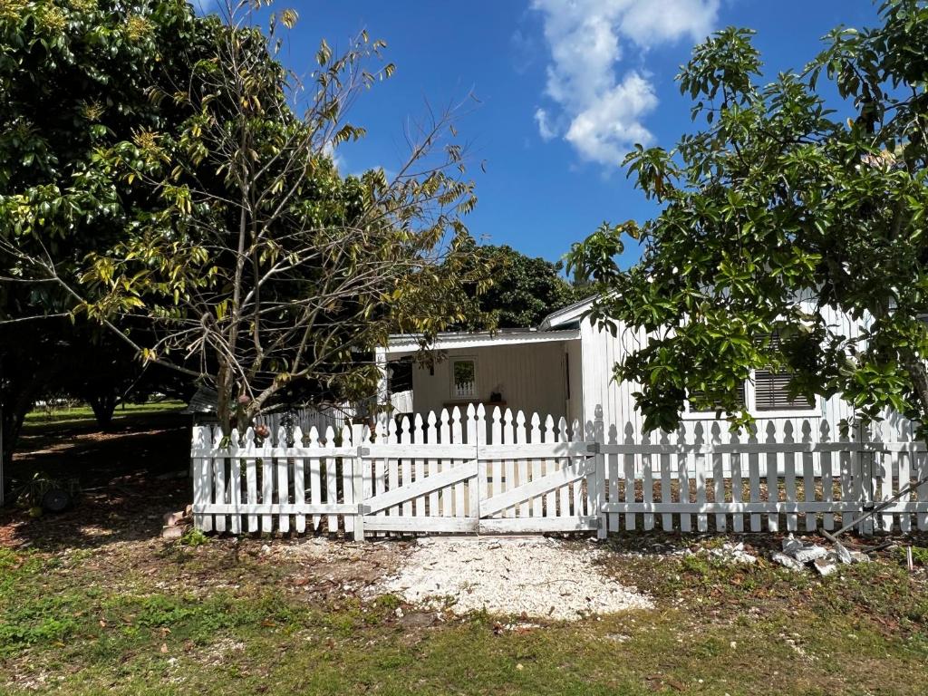 a white picket fence in front of a house at Maria's Farm House in Homestead