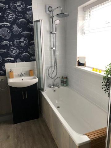 a bathroom with a tub and a sink and a shower at Emily House in Redcar