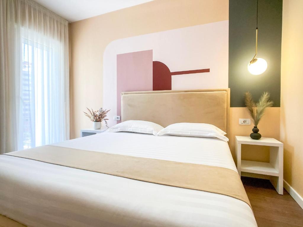 1 dormitorio con 1 cama grande con sábanas blancas en Phi Apartments 1 min from the beach - New Additions, en Durrës