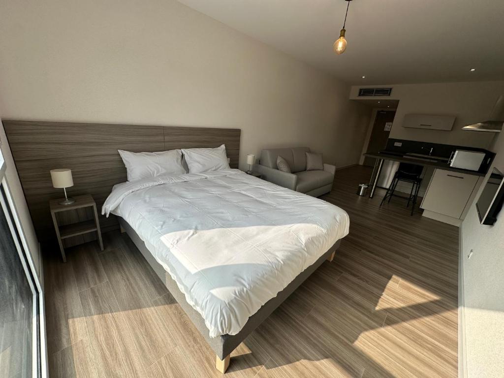 um quarto com uma cama grande e uma sala de estar em Musieges Appart'Hôtel 