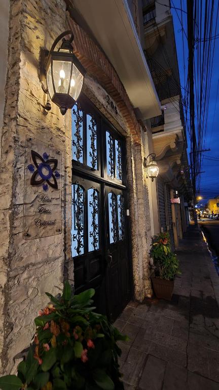 ein Gebäude mit einer schwarzen Tür und einer Lampe in der Unterkunft Hotel Class Colonial in Santo Domingo
