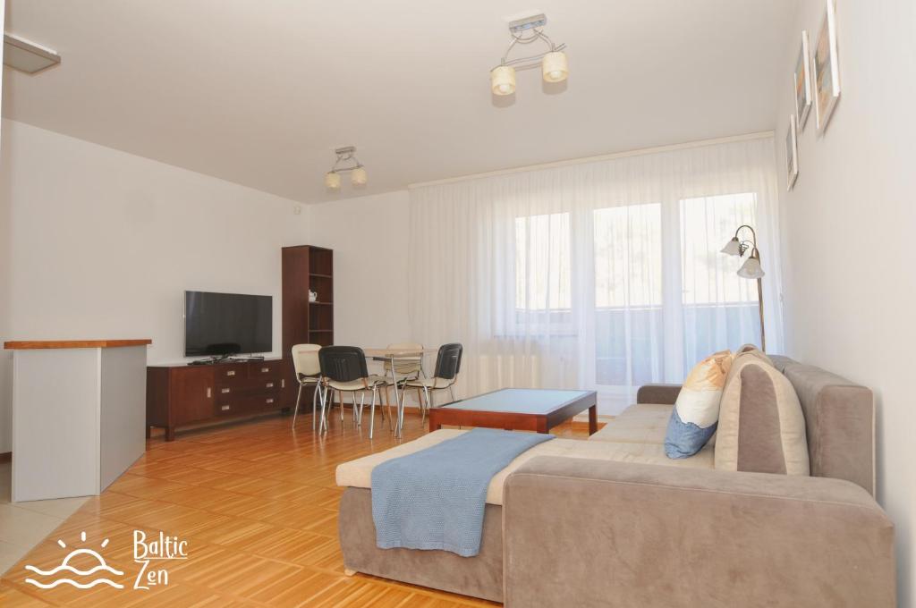 een woonkamer met een bank en een eetkamer bij Baltic Zen - Apartament in Hel