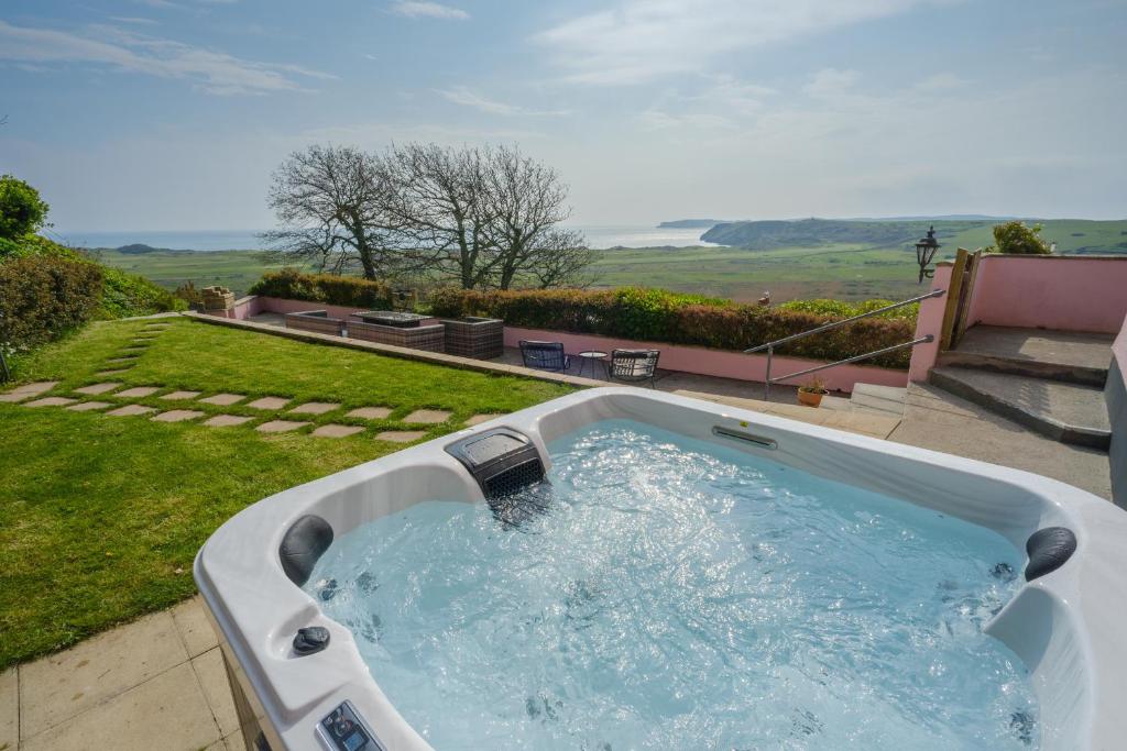 a jacuzzi tub in the backyard of a house at Priory Bay Escapes - Matahari in Tenby