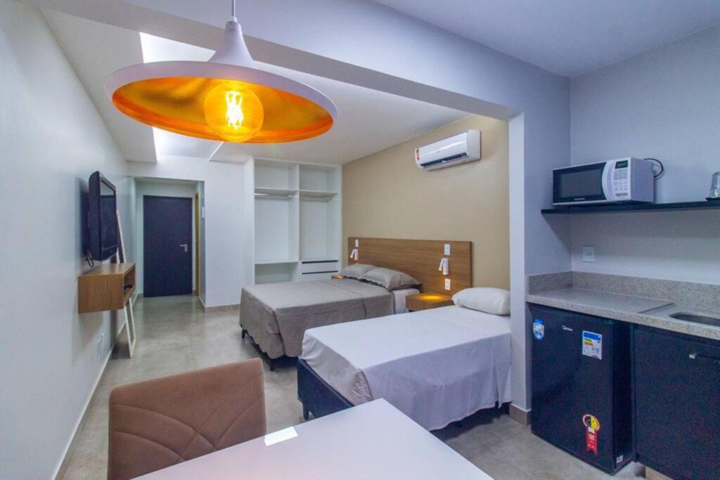 a hotel room with two beds and a large light at GARVEY FLAT in Brasilia