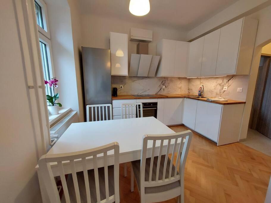 eine Küche mit einem weißen Tisch und Stühlen in der Unterkunft Apartment Bezigrad in Ljubljana