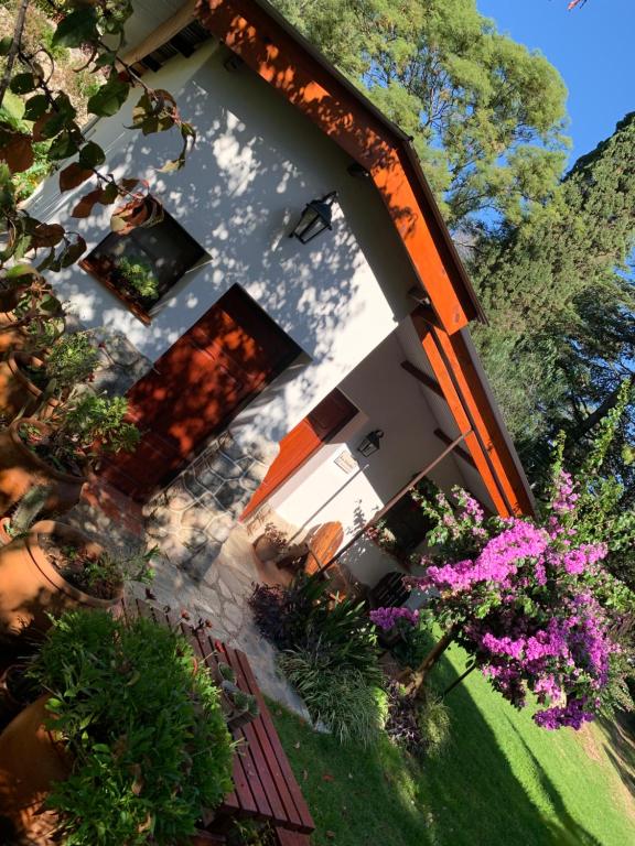 einen Blick über ein Gebäude mit Blumen und Bäumen in der Unterkunft La Linda de la Aldea Serrana in La Falda