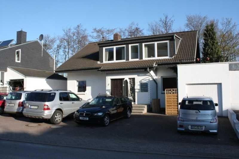 a group of cars parked in front of a house at Gaestehaus Denecke in Scharbeutz