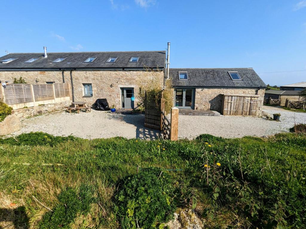 a stone house with a large yard in front of it at Treverrows Barn - Barn Conversion on the Farm in Penryn