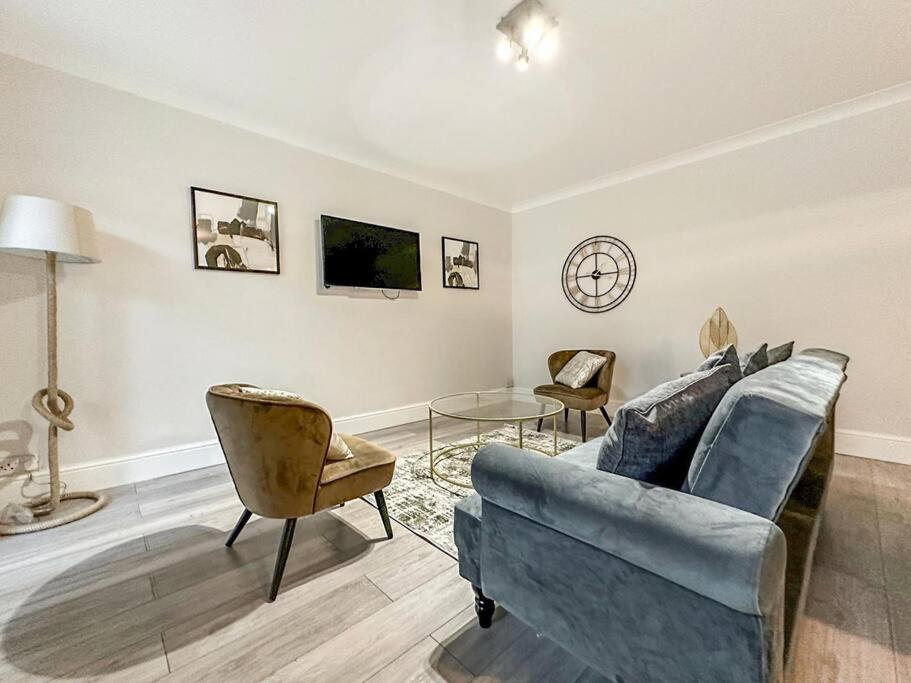 sala de estar con sofá azul y sillas en New Cosy Luxury 3 Bedroom House in Battersea London en Londres
