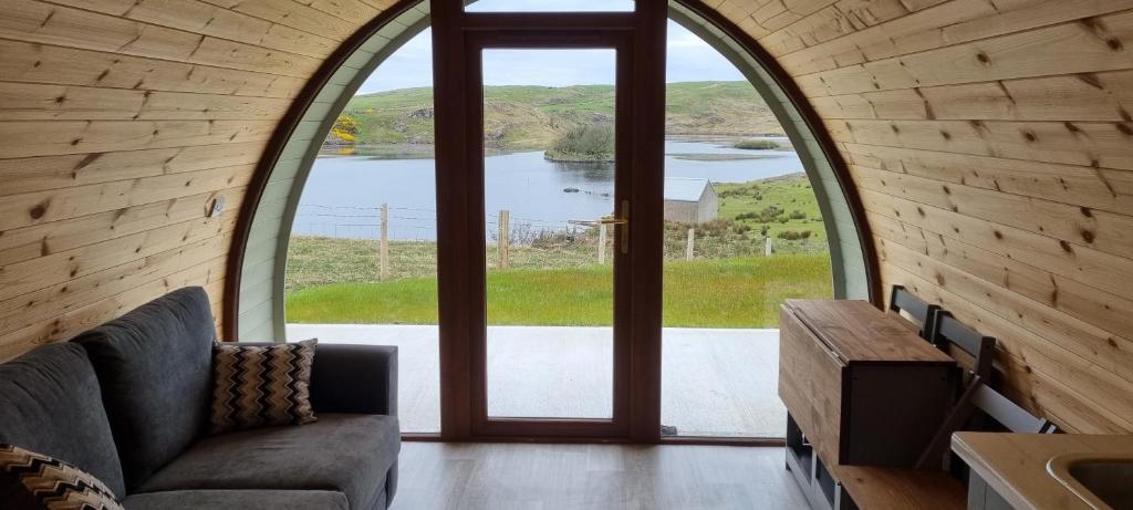 a living room with an arched window and a couch at Fairhead Glamping Pods in Ballycastle