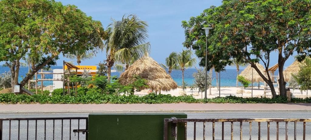 a beach with a fence and trees and the ocean at Studios with beautiful sea view in Willemstad