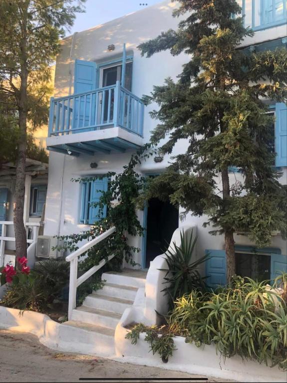 a white house with a blue balcony and stairs at Mykonos efis maisonette in Mikonos