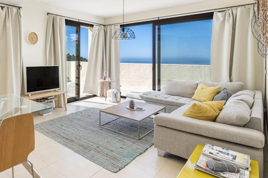 - un salon avec un canapé et une vue sur l'océan dans l'établissement Joyful PH w/ stunning Sea Views, à Marbella