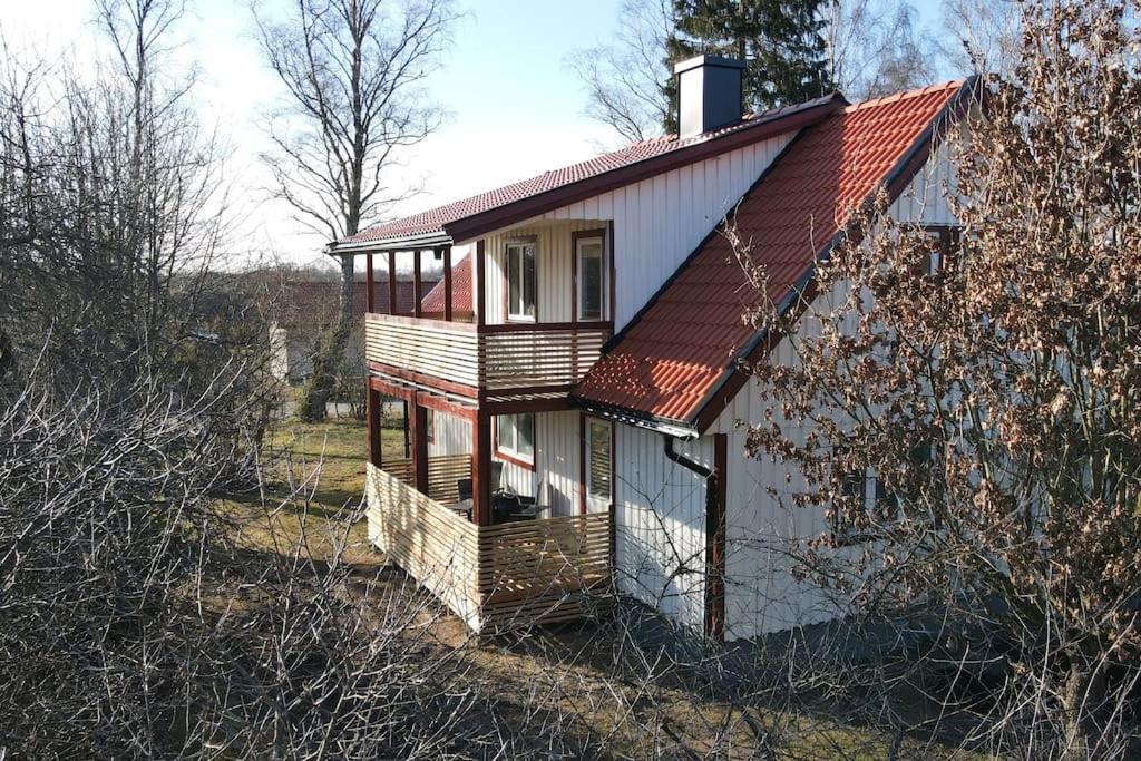 een klein wit huis met een rood dak bij Lantlig villa i Ljungbyhed in Ljungbyhed