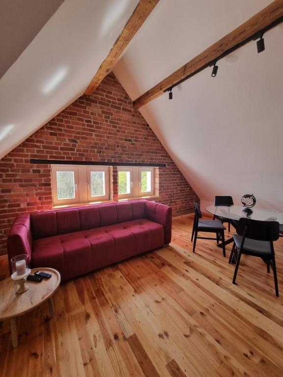 a living room with a red couch and a brick wall at Apartament Relax in Toruń