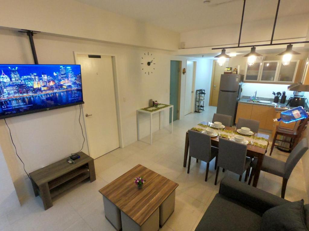 a living room with a television and a dining room at Sundance Residences, your home at the heart of the city! in Cebu City