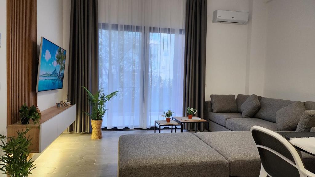 a living room with a couch and a large window at Solar Rooms and Apartments in Himare