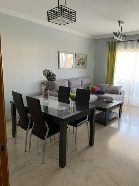 a dining room with a table and a couch at Residencial Duquesa Fase 1 in Manilva