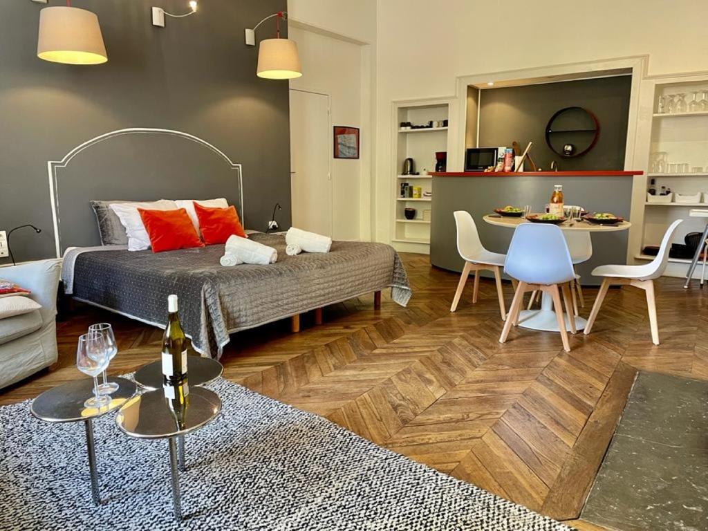 een woonkamer met een bed en een eetkamer bij Appartements Caractere Clos St Jean in Mâcon