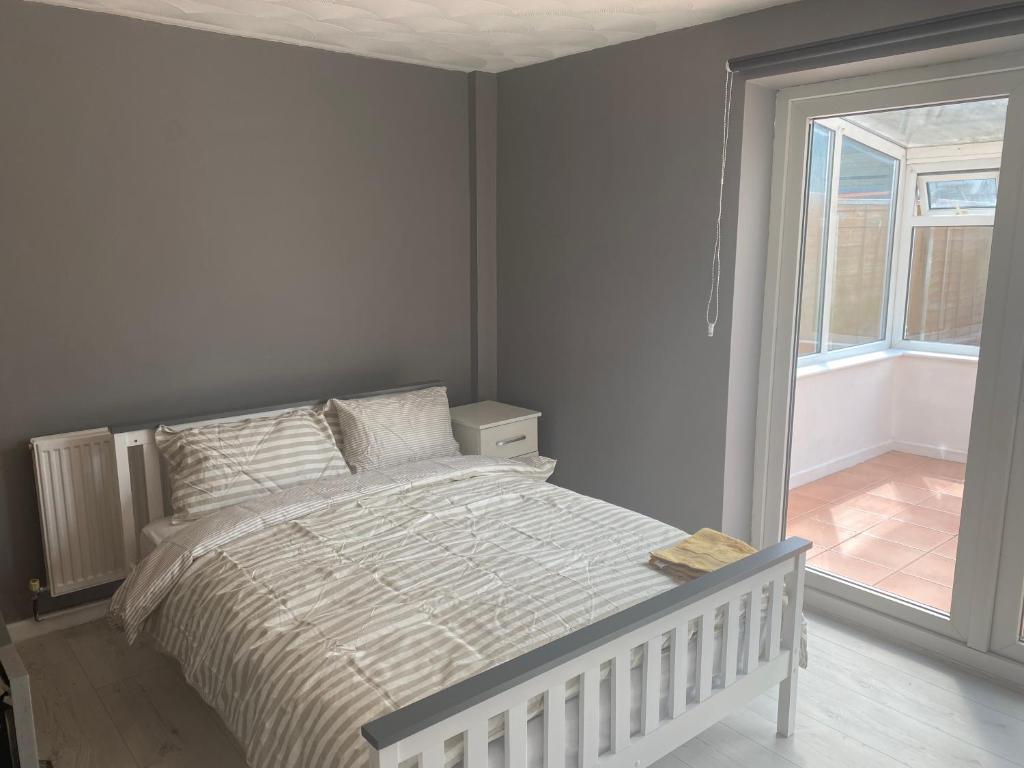 a white bedroom with a bed and a window at Cosy Room in Bristol in Bristol