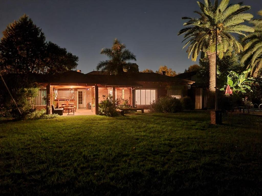 a house with a palm tree in front of a yard at Nagual B&B - Airport Shuttle in Tristán Suárez