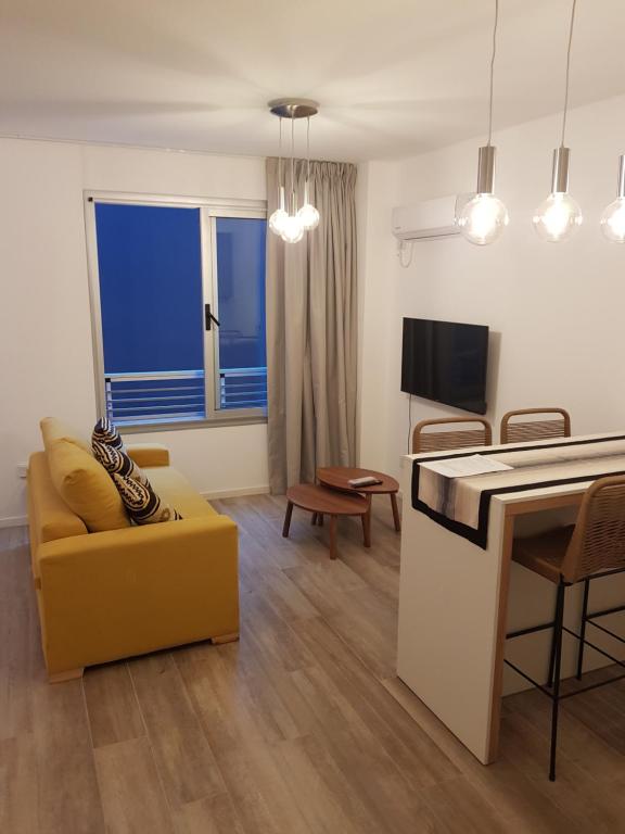 Godoy House في بوينس آيرس: غرفة معيشة مع أريكة صفراء وطاولة