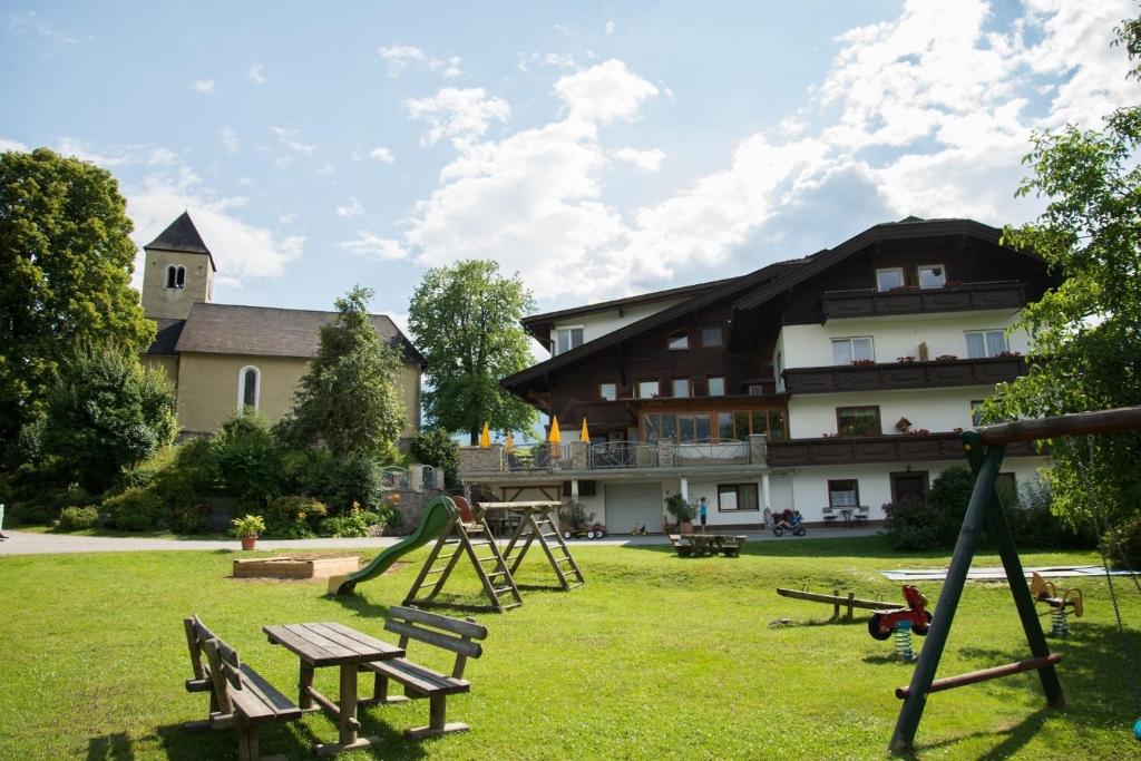 un parc avec des équipements de jeux et un grand bâtiment dans l'établissement Familiengasthof St. Wolfgang, à Spittal an der Drau