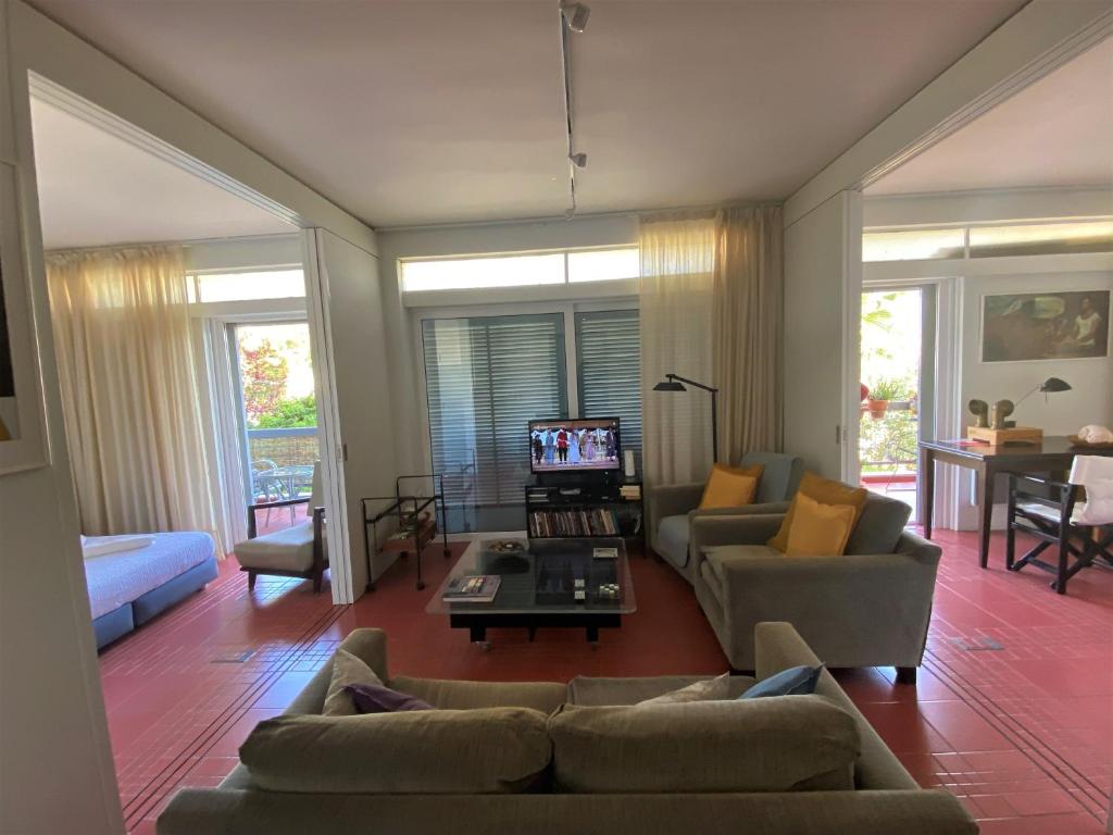 a living room with two couches and a tv at Argyro suite Rafina in Rafina