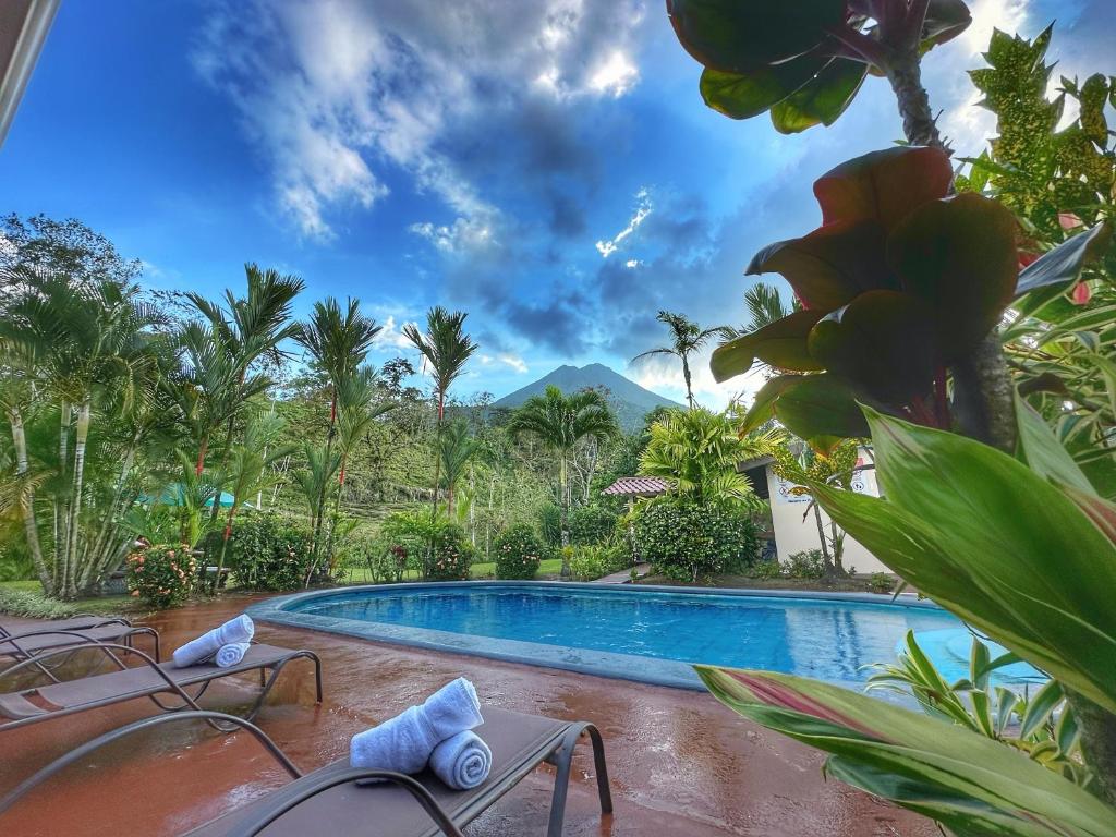 a swimming pool in a resort with mountains in the background at Loma Real Hot Springs Bed & Breakfast in Fortuna