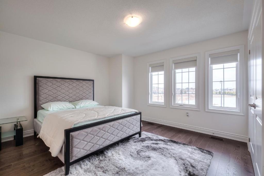 a bedroom with a bed and two windows at Unwind Here in a Stylish and Cozy Space in Bradford