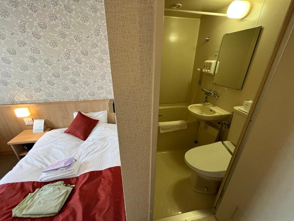 une petite salle de bains avec un lit et des toilettes dans l'établissement Monbetsu Prince Hotel, à Mombetsu