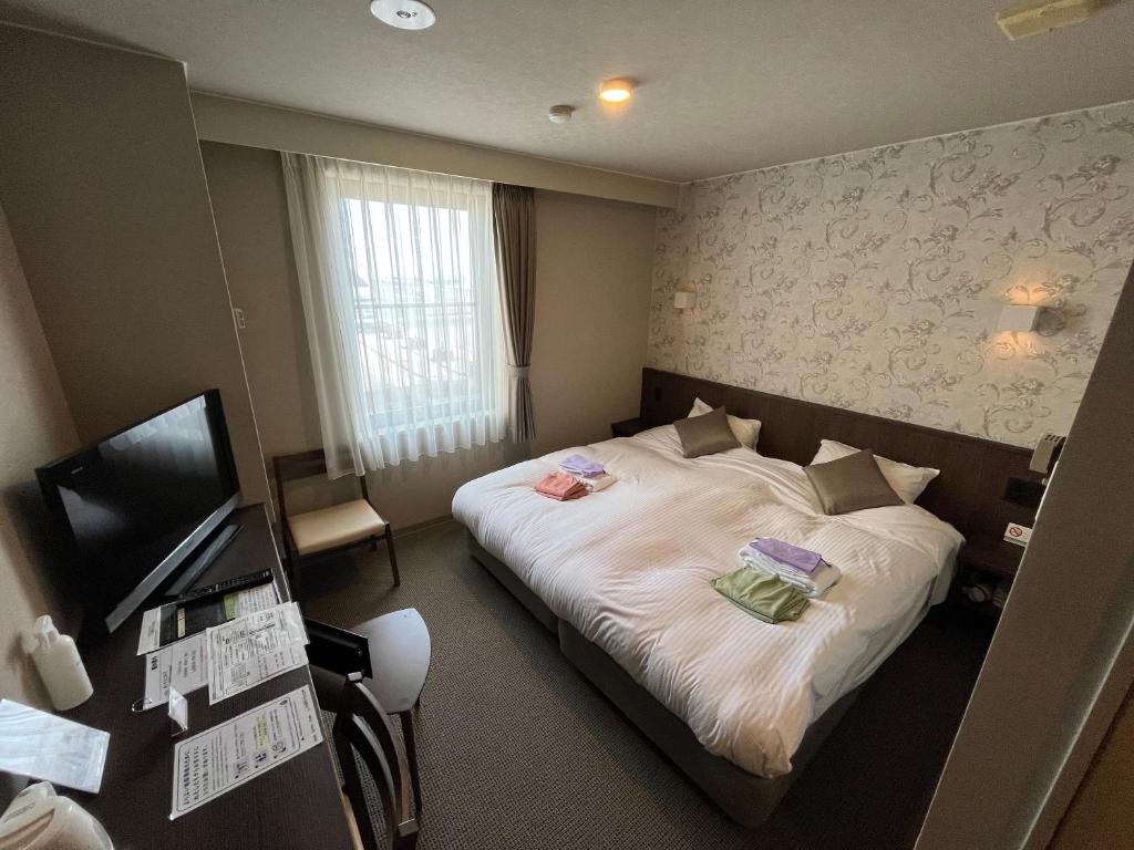une chambre d'hôtel avec un lit et un bureau dans l'établissement Monbetsu Prince Hotel, à Mombetsu