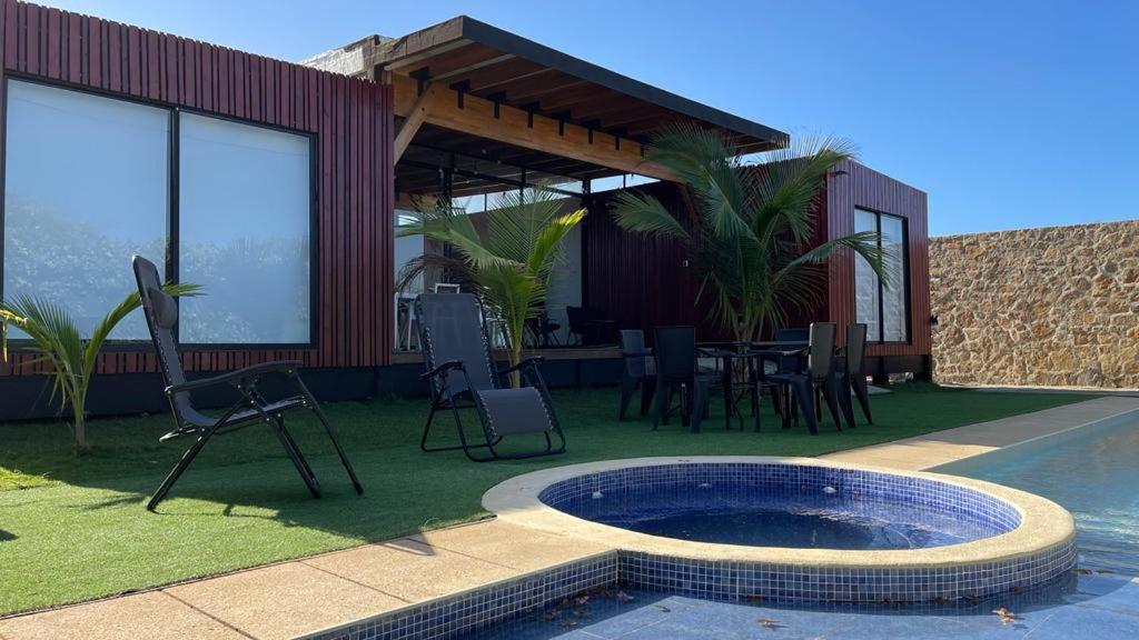 une maison avec une piscine, une table et des chaises dans l'établissement VILLA KITE Habitaciones cuadruples LUJO , SALINAS DEL REY, à Juan de Acosta