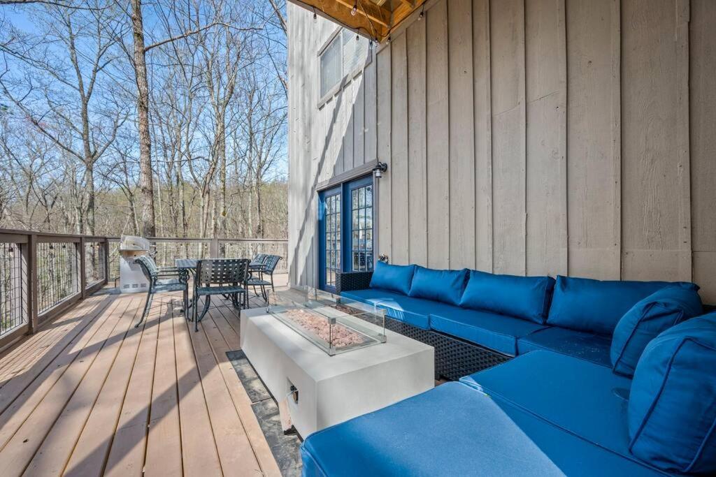 a patio with a blue couch and a table on a deck at Baileys Mountain Retreat in Gatlinburg