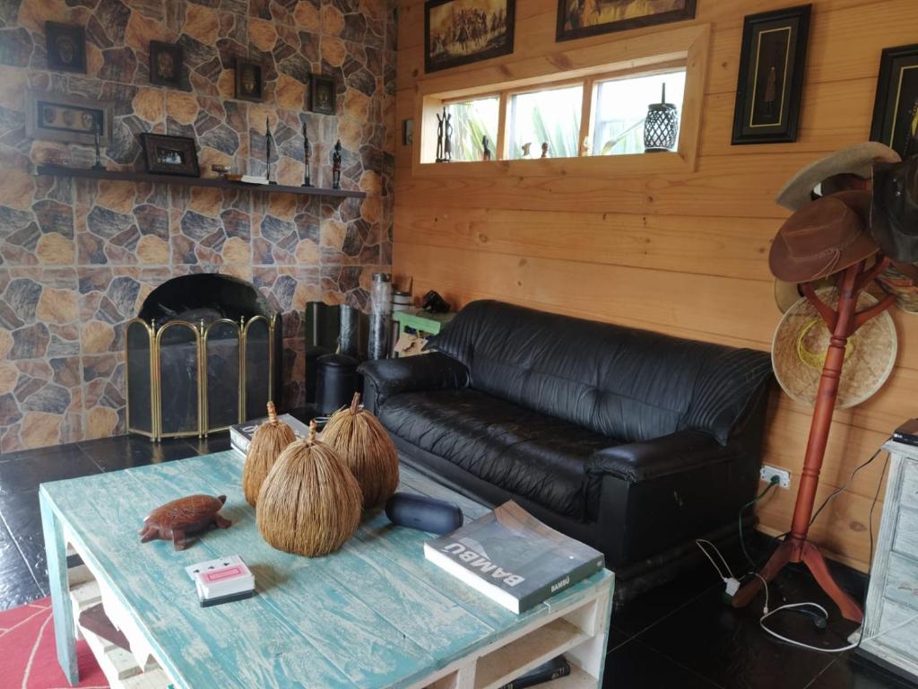 a living room with a leather couch and a table at Cabaña Luna Verde in San Vicente